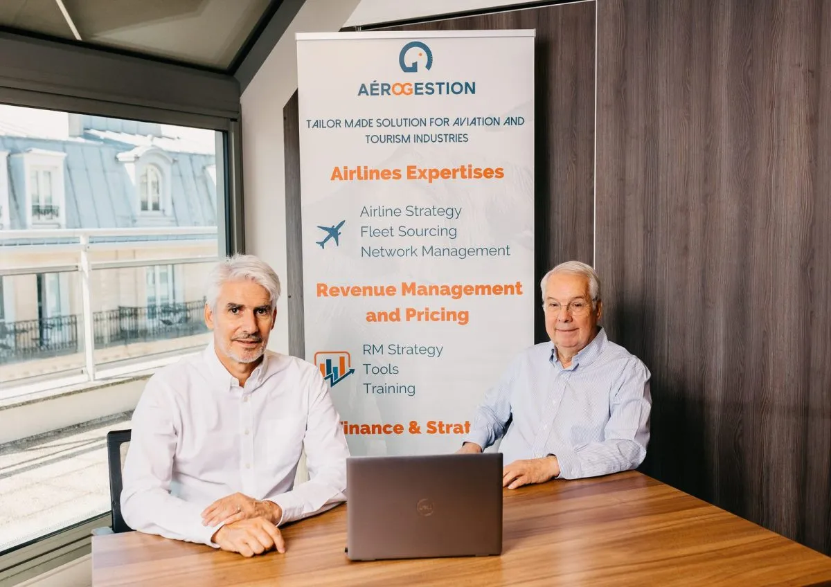 Two partners in front of the Aérogestion banner