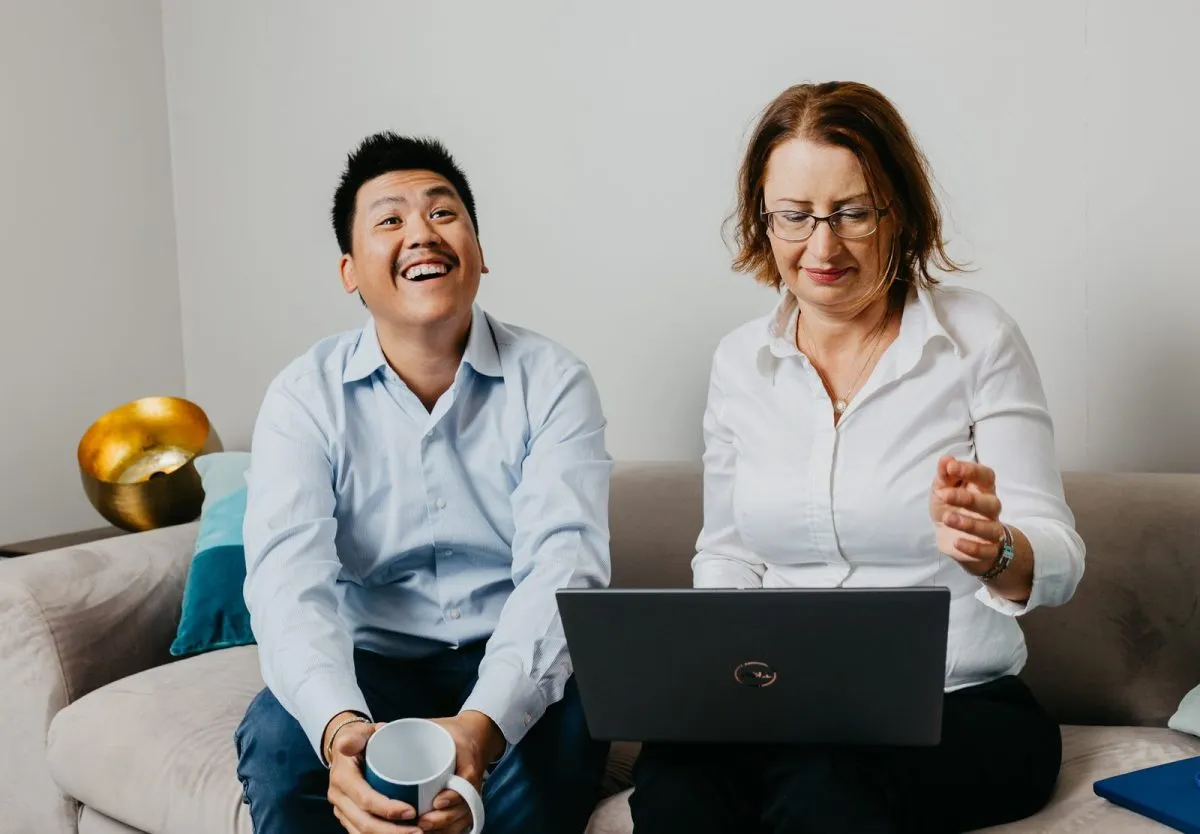 Two consultants in discussion in front of a laptop
